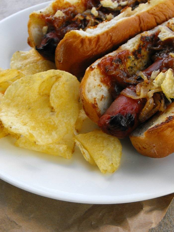 Southern Style hot dogs topped with smoked mustard, pulled pork, caramelized onions and kettle chips