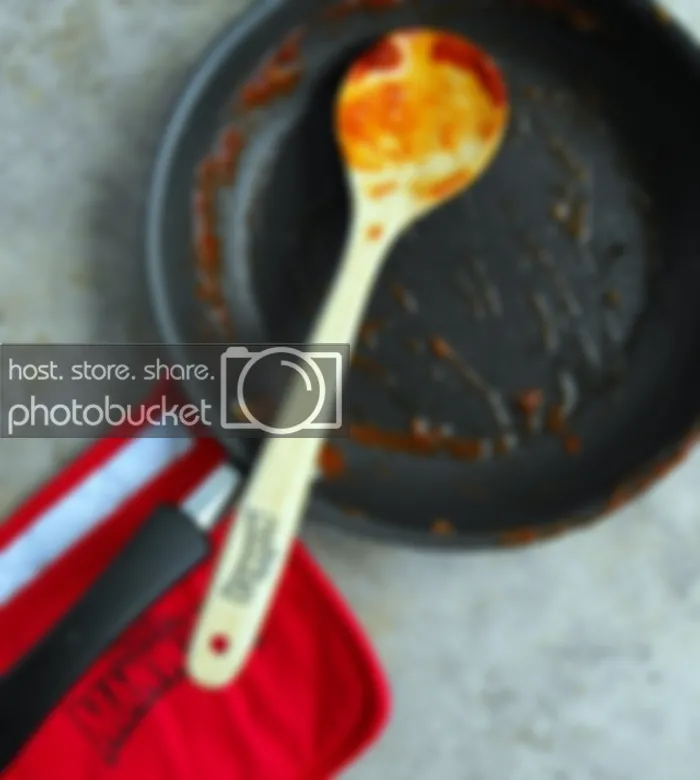 Cooking up Manwich with wooden spoon and pot holder